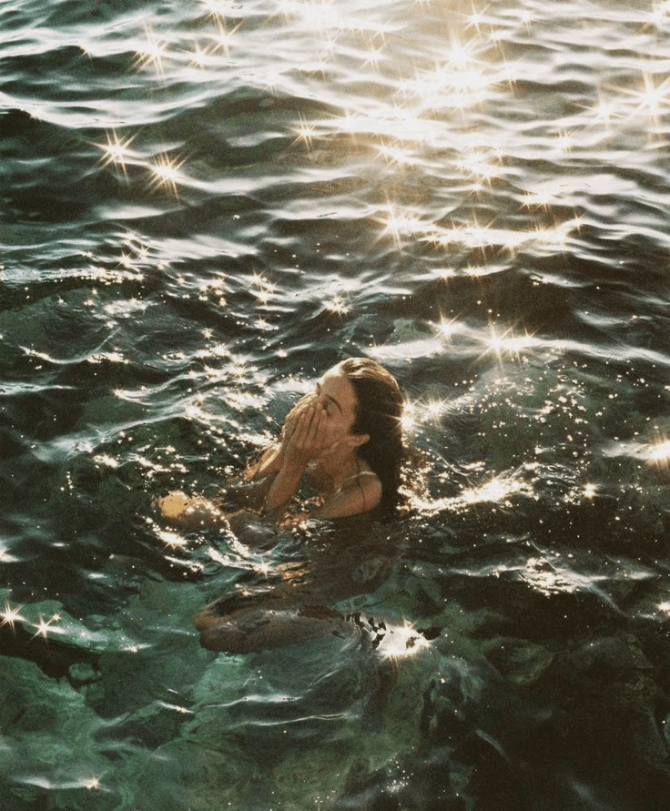 Person swimming in sunlit water